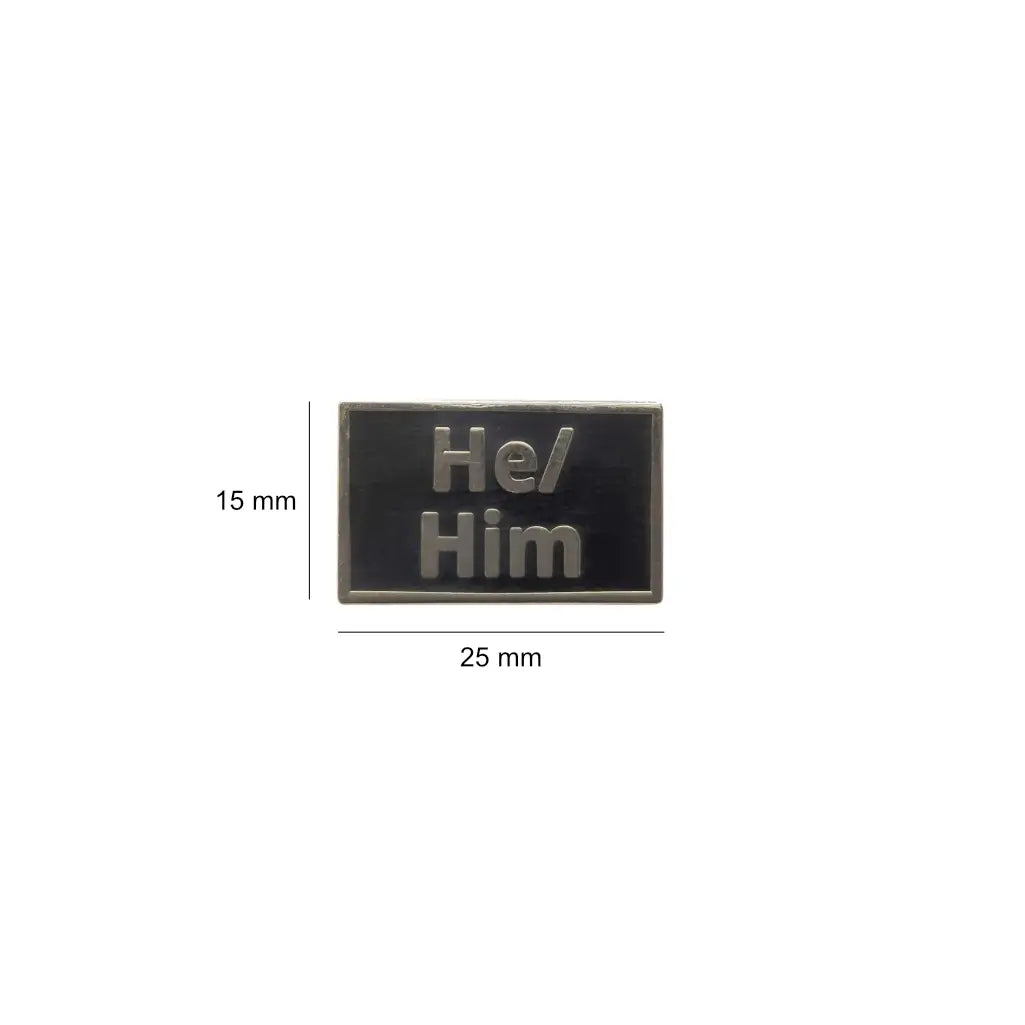 Black He/Him lapel pin with metallic raised text, shown with dimensions of 25mm wide and 15mm tall compact and stylish, perfect for jackets, backpacks, or lanyards.