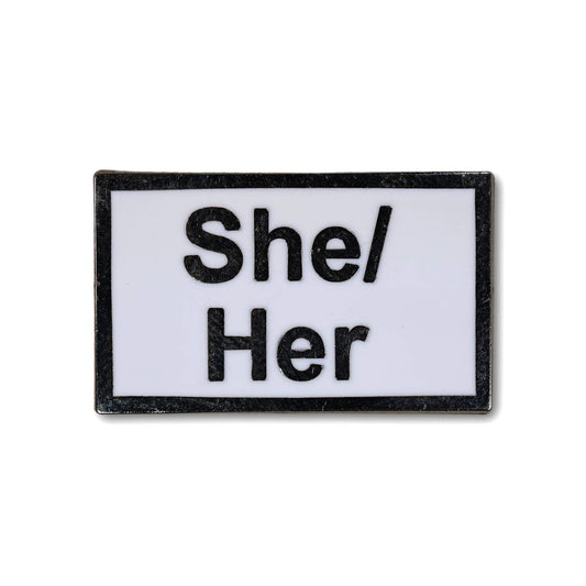 Rectangular enamel pin with 'She/Her' text on a white background